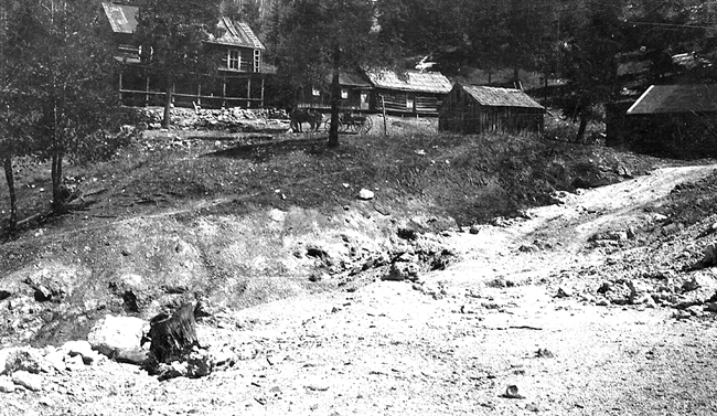 Photo of Sulphur Springs hotel and bath houses, April 16, 1918. Photo is black and white with buildings, tree and a horse-drawn carriage.