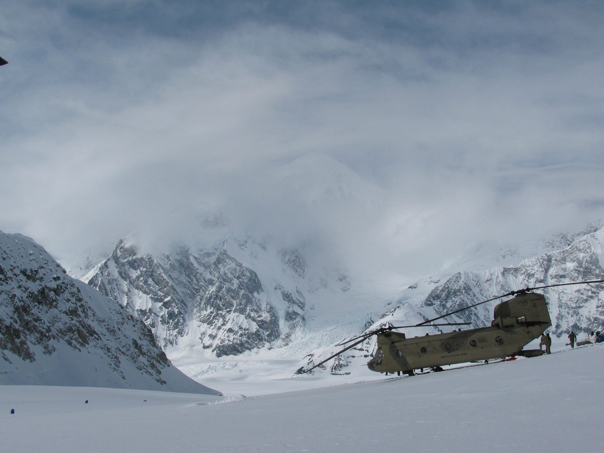 A CH-47 lands on the Kahiltna Glacier, surrounded by snowy peaks