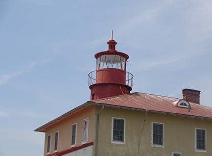 Lighthouse with red roof and tan siding