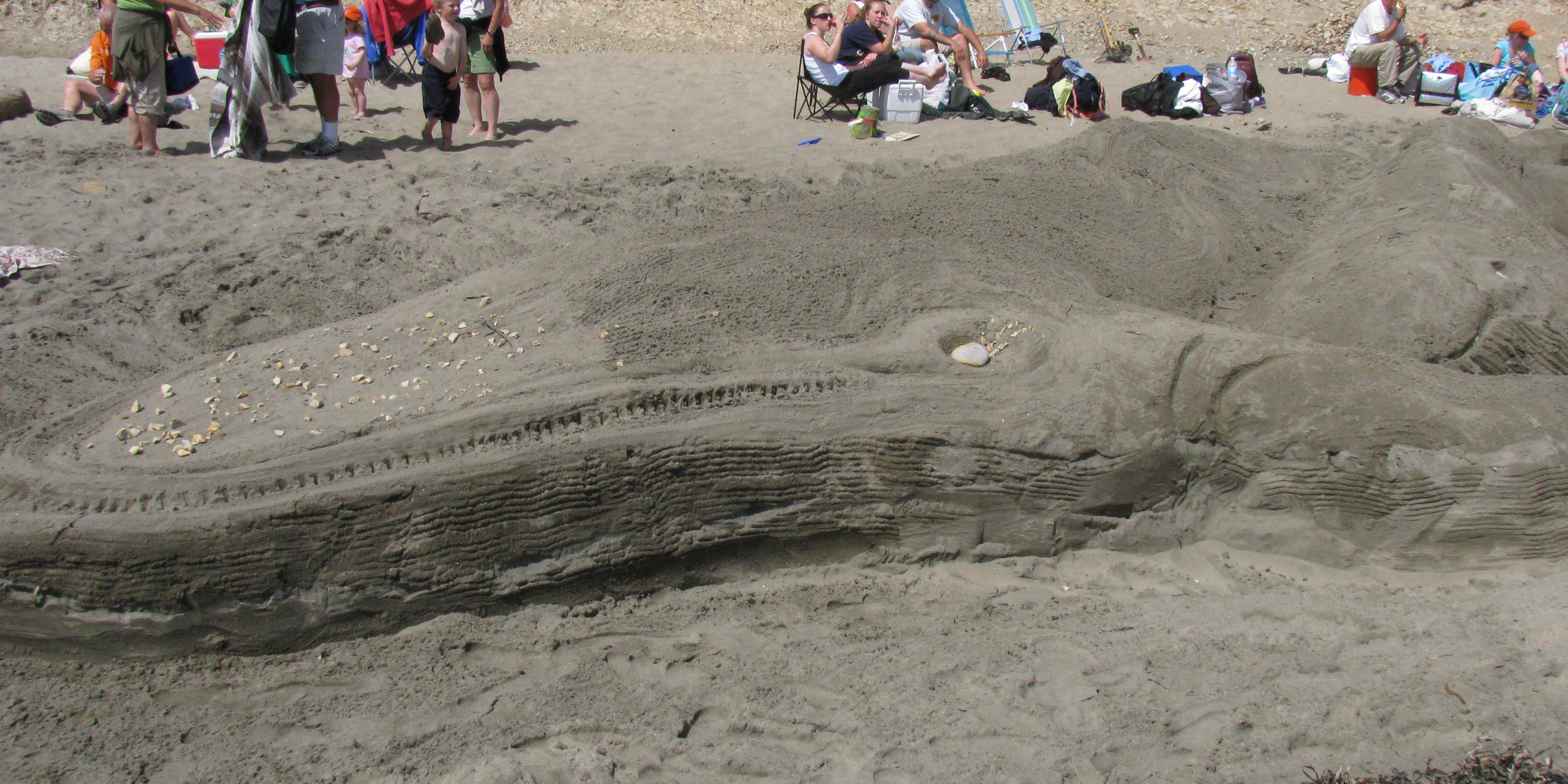 A large sand sculpture of a blue whale.