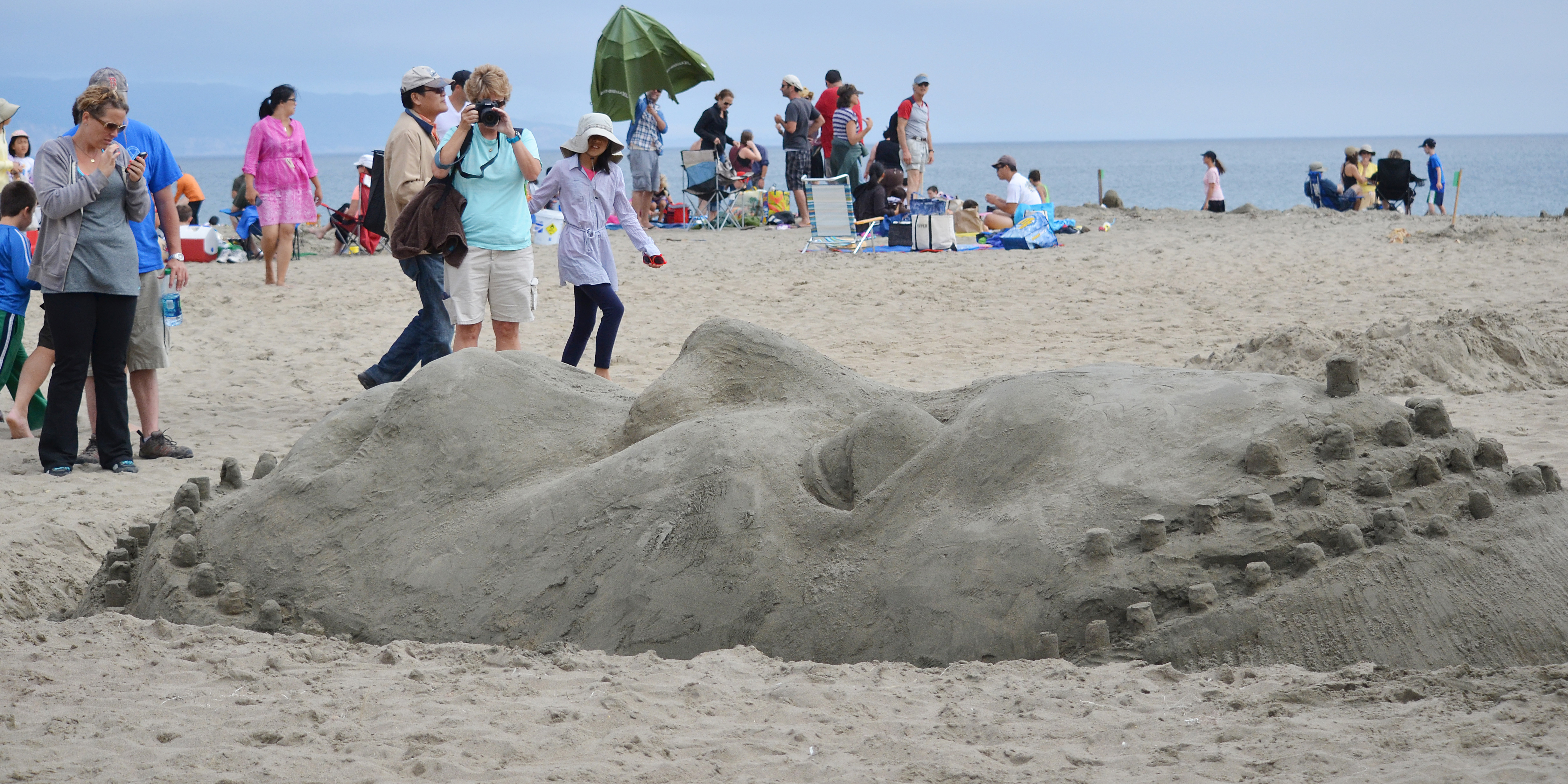 A large sand sculpture of the face of Achaemenid Empire King Darius rising out of the sand.