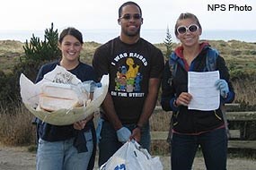 Three Beach Cleanup Volunteers with litter collected from Limantour Beach.