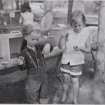 a black and white photo of children at play with a turtle