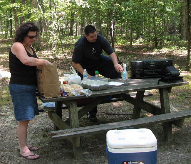 A woman and man unload camping supplies