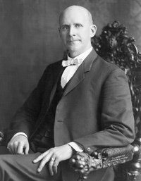 Eugene V. Debs seated in an ornate wooden chair.