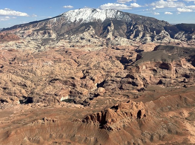 Aerial view of round grey snow topped mountain
