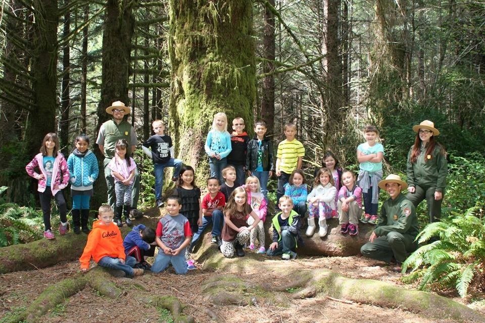 Three rangers and class take picture under Grandfather Spruce tree.