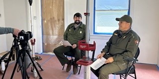Two seated employees being filmed for an interview.