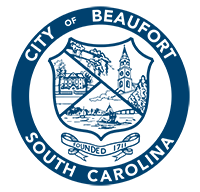 "City of Beaufort, South Carolina" written in a circle around a shield with a historic house, church tower, and boat in a bay. Under the shield is a banner "Founded 1711."