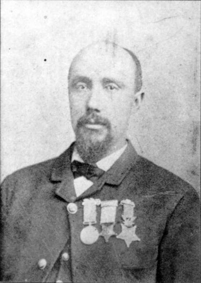 A post war photograph of Robert Pinn.  He has three medals on his chest, one the Medal of Honor, one the Butler Medal, and one unknown.