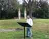 visitor reads wayside with two chimneys in background