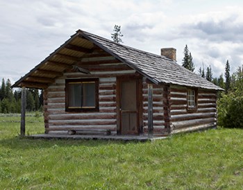 Restored log cabin with pitched roof and small porch