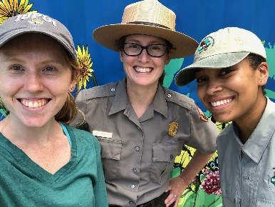 Close up of three young women smiling. The woman is wearing a ranger uniform.