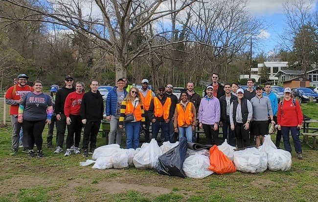 Group of volunteers standing with collection of trash bags