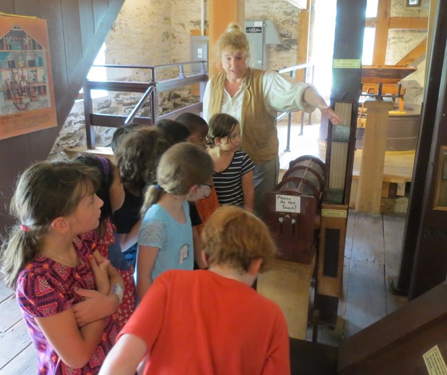 Miller Jeanne shows kids how the bolter separates different sizes of grain