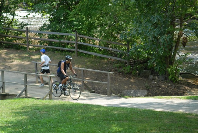 Runners and bikers along the path to Peirce Mill