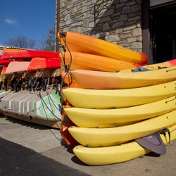 Kayaks piled on-top of each other at the Thompson Boat Center