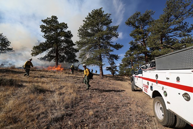 NPS fire crews with a fire truck are managing a prescribed fire in RMNP