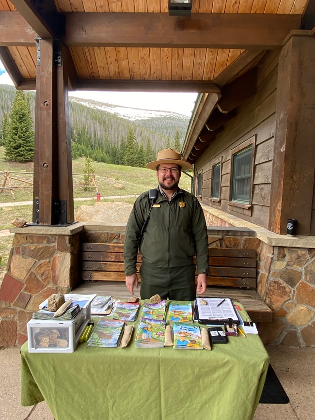 A Park Ranger is standing outside at Junior Ranger Headquarters at Hidden Valley in summer