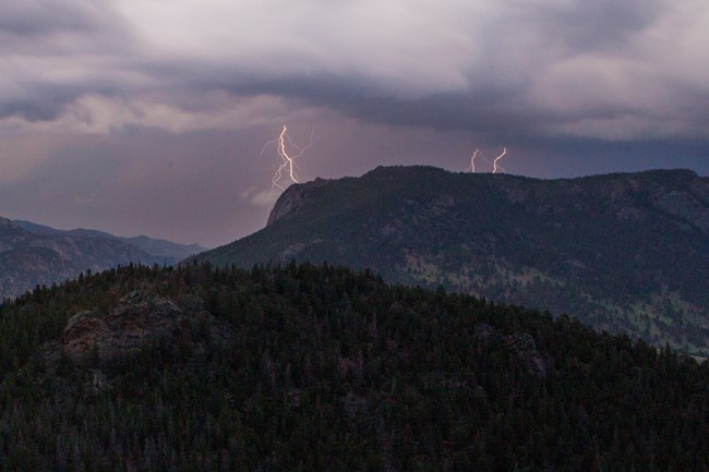 lightning bolts in the distance over mountains