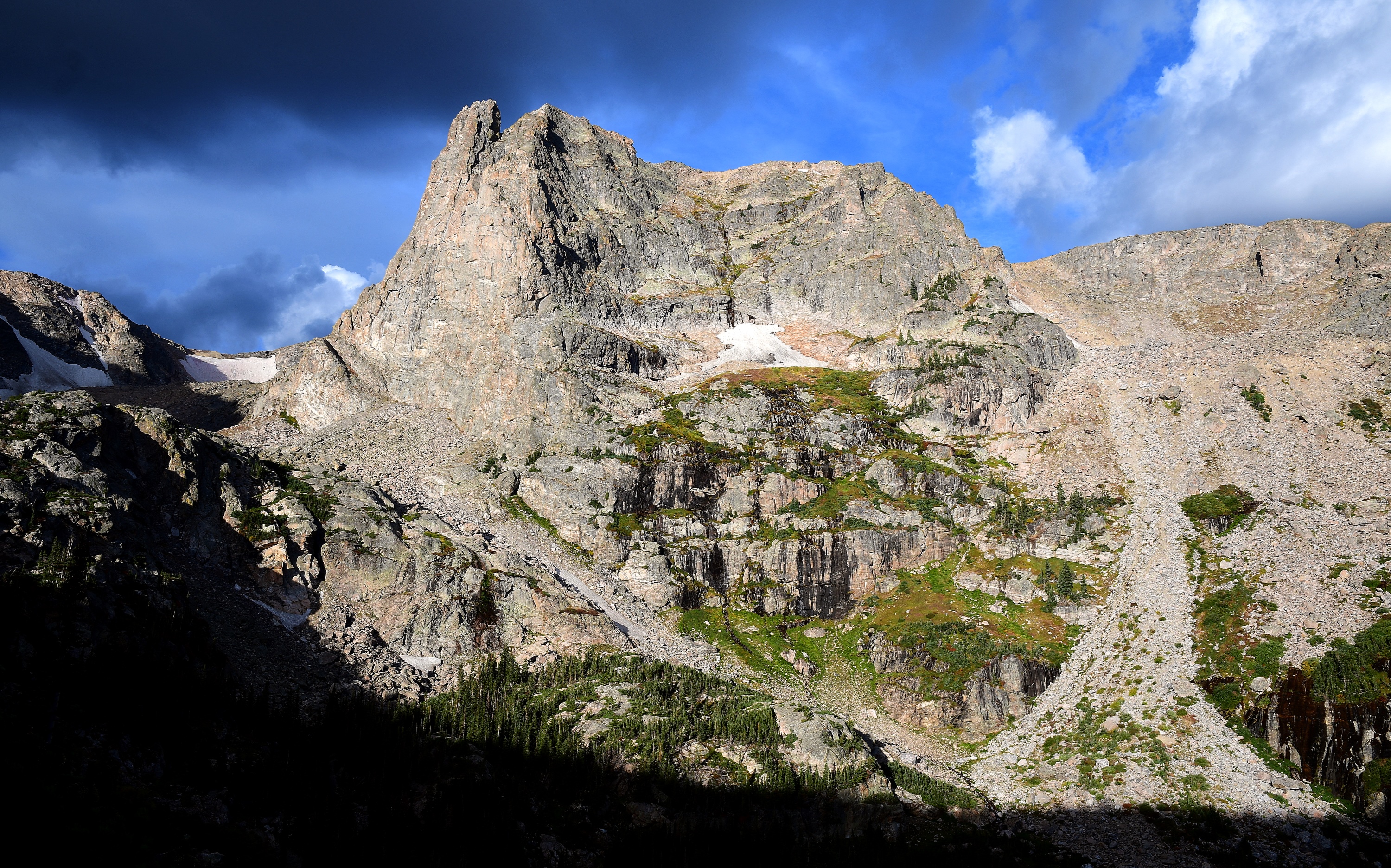 Notchtop Mountain on a clear, early September day with Dark Storm Clouds overhead