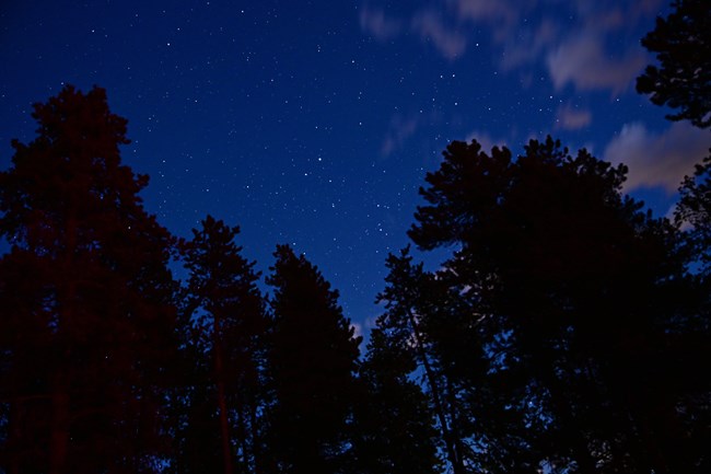 View of stars in the night sky at night, with some clouds.