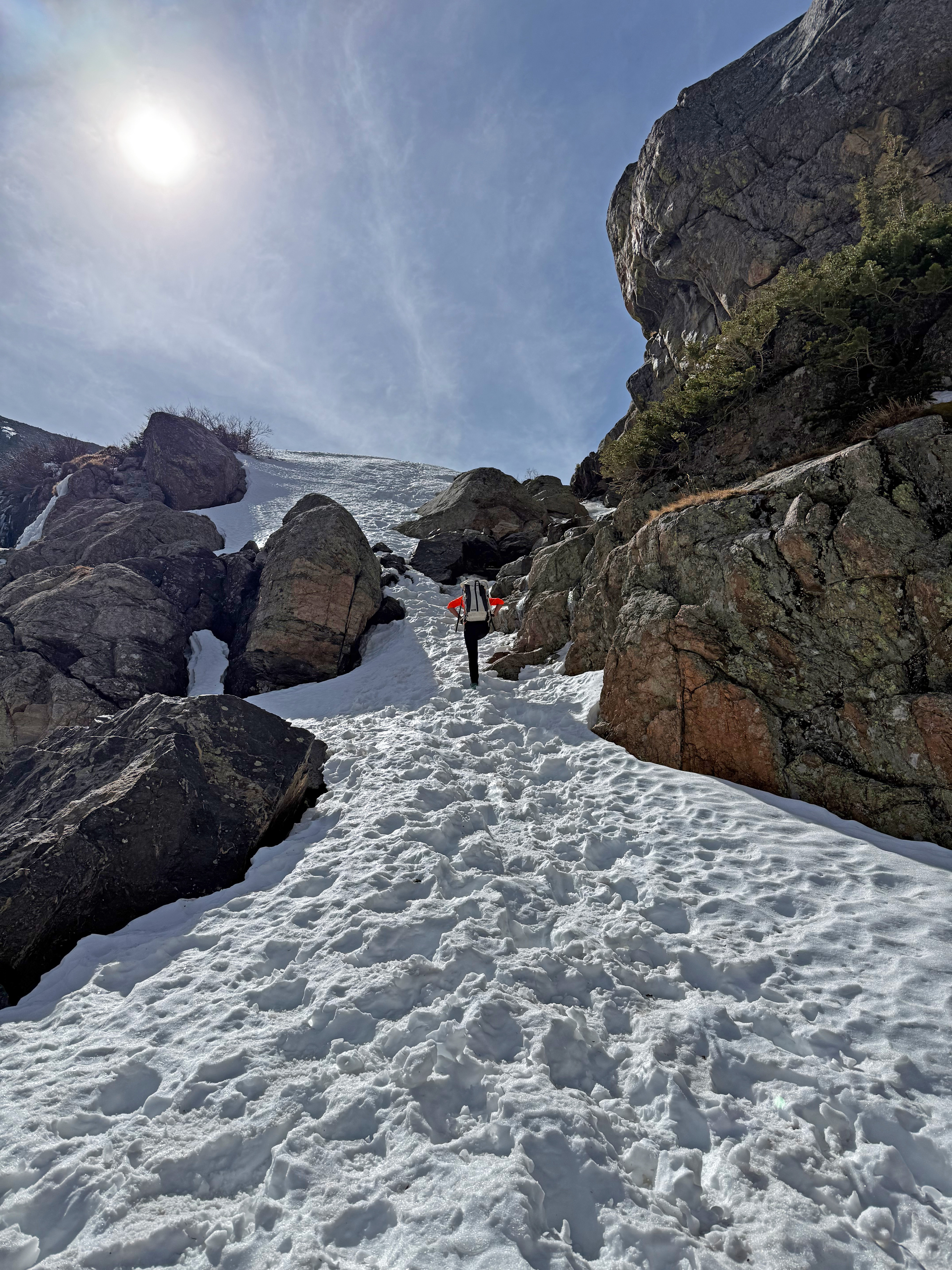 A steep trail is covered with deep snow and slippery ice