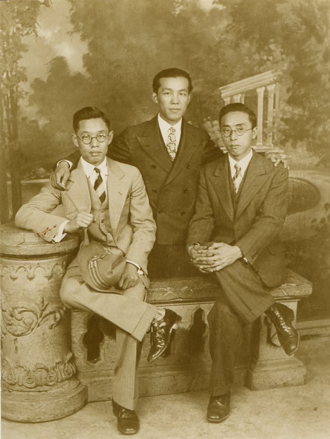 Three young Chinese men in suits pose for the camera.