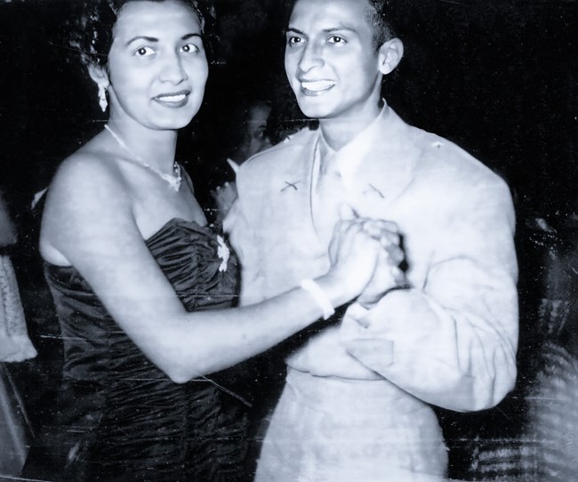 A young woman and man in formal wear are dancing.