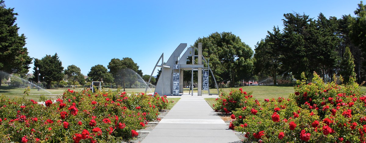 Image of flowers and sidewalk leading to the Rosie Memorial.