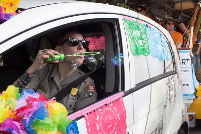 Park Ranger blows bubbles while sitting in a park electric car