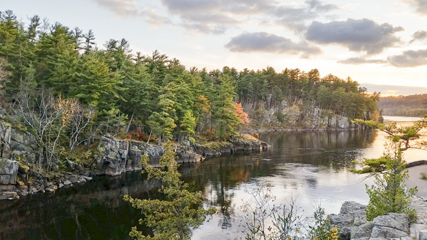 Evening light falls on a cliff and river.