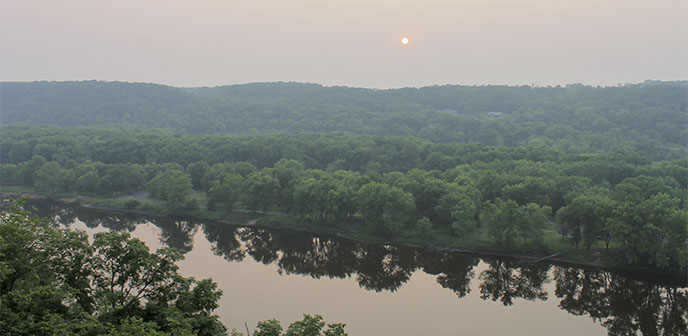 The sun sets over a river.