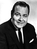 Black and white publicity portrait of Jonthan Winters in a black suit