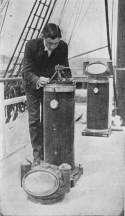 Black and white photograph of James Percy Ault bending over and handling scientific instrument