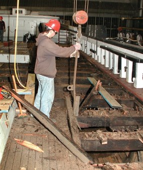 Ship yard worker exposing rotting deck planks.