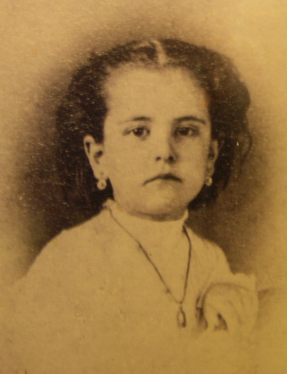 historical portrait photo of a young girl age 8, looking towards the camera