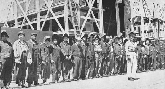 a group of welders stand together in a shipyard in 1943