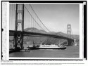 Black and white photo of the steamship President Hoover passing under the Golden Gate Bridge