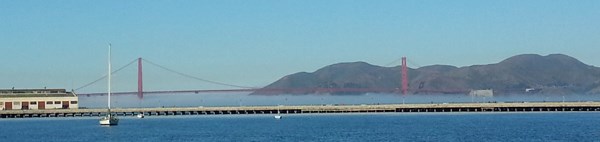 The Golden Gate Bridge with fog forming below the main deck.