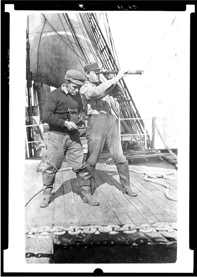 Two men standing on the deck of a ship.