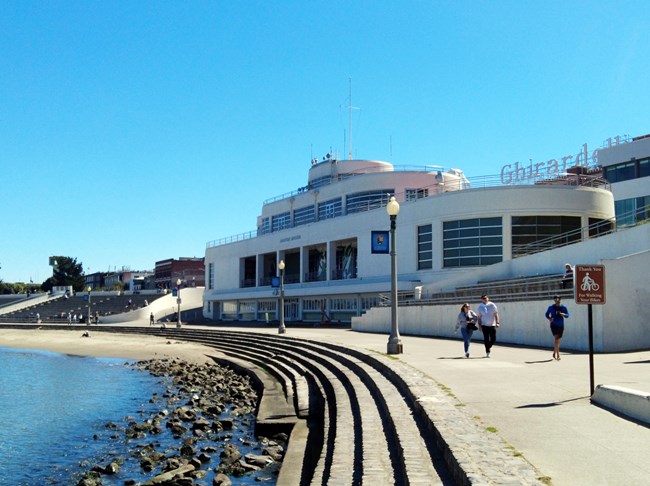 a white building designed to look like an ocean liner ship near a rocky shoreline