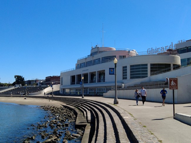 a white building designed to look like an ocean liner ship near a rocky shoreline