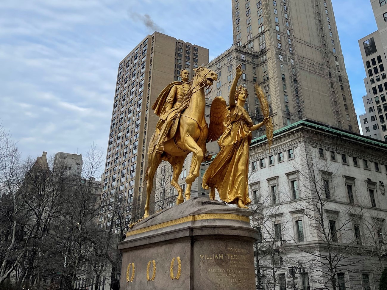 gold-colored statue of angel and man on a horse