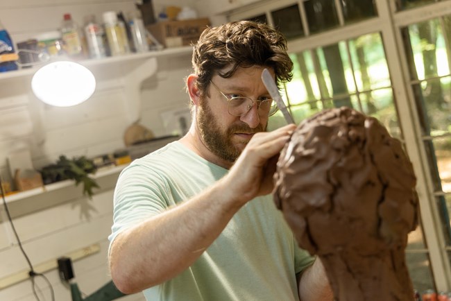 sculptor working on clay bust