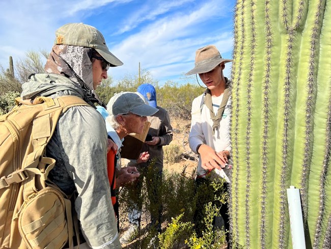 multiple people look at an example of how to use the compass for the saguaro study