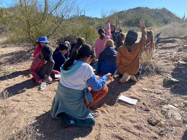 students in a wash, some with hands raised