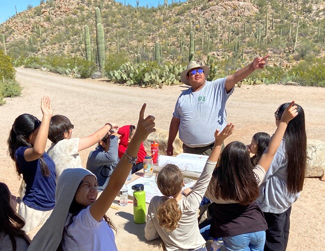 kids and ranger pointing into the sky