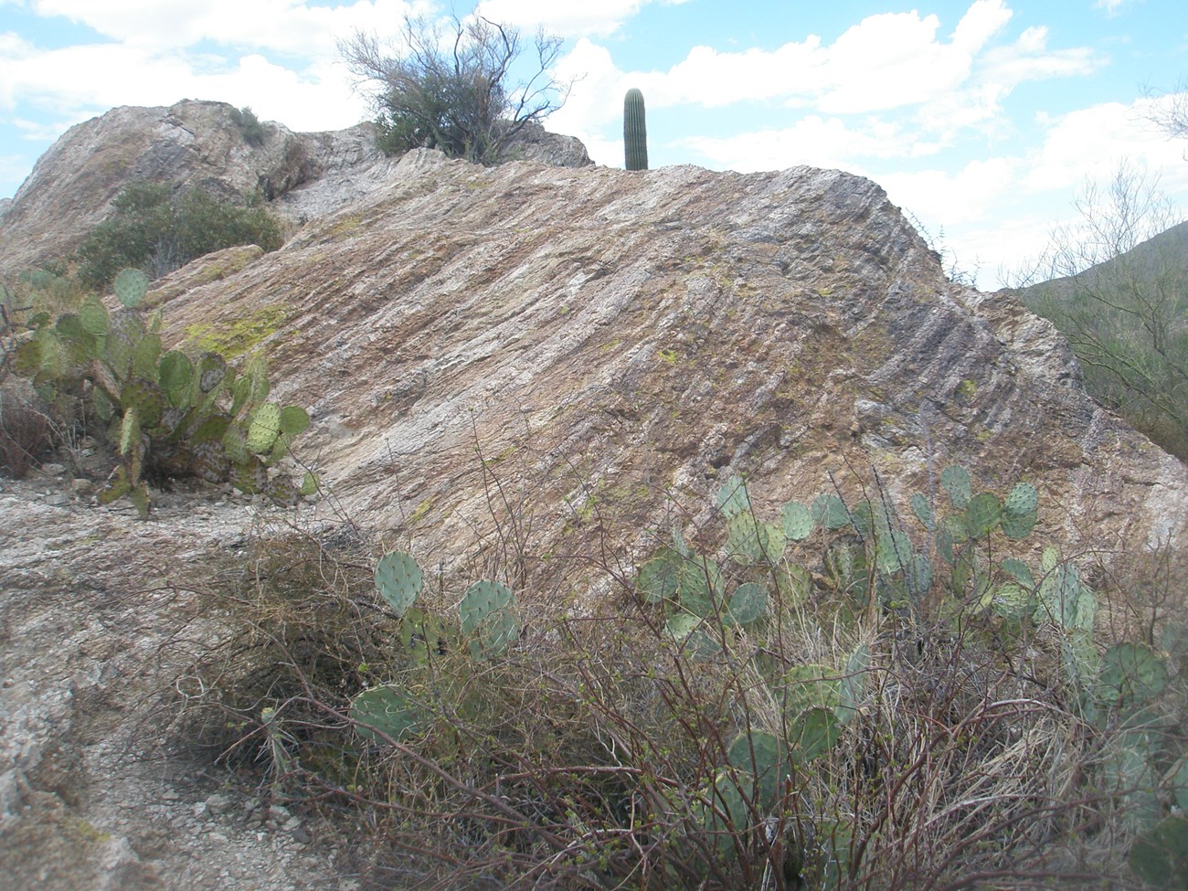 large rock formation with stripes of minerals