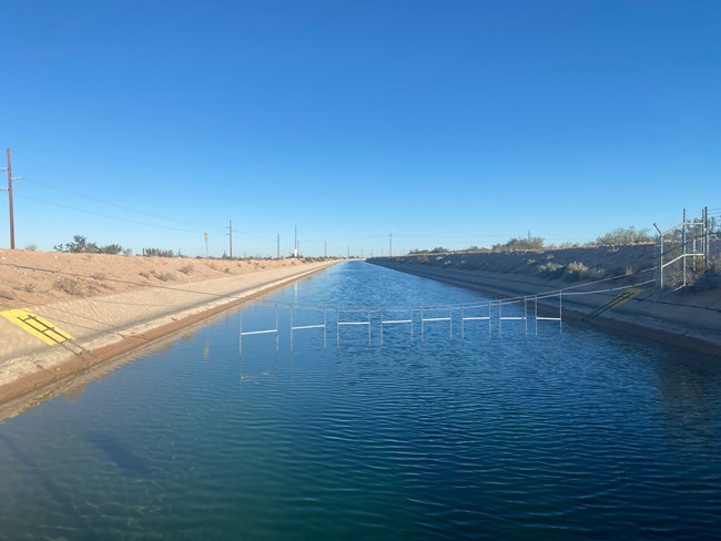 A large open canal of blue water known as the Central Arizona Project (CAP).